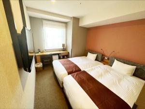 a hotel room with two beds and a window at HOTEL SUI AKASAKA by ABEST in Tokyo