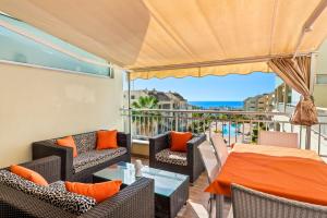 a balcony with furniture and a view of the ocean at Luxuriöse Duplex Ferienwohnung in sehr ruhiger Wohnanlage mit Meerblick in Palm-mar