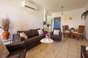 ein Wohnzimmer mit einem Sofa und einem Tisch in der Unterkunft Resitour - Regina Gardens in Paphos City