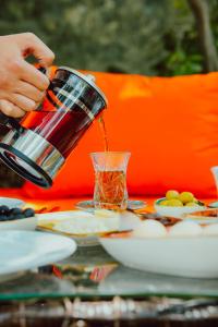 a person pouring tea into a cup on a table at LakeSide Hotel & Spa in Gabala