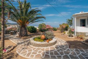 un jardín con plantas y árboles y una casa en Nostos Sifnos en Apollonía