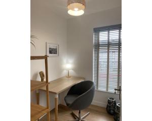 a desk and a chair in a room with a window at Central Belfast Apartments BELFAST WORK-REST-PLAY R&R in Belfast