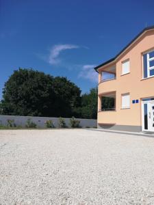 une maison avec une allée en gravier en face de celle-ci dans l'établissement Apartments Oleander Lovrečica, à Lovrečica