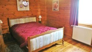 ein Schlafzimmer mit einem Bett in einem Holzzimmer in der Unterkunft Le chalet du mazagran 
