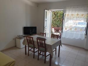 une salle à manger avec une table, des chaises et une télévision dans l'établissement Apartments Dubravka, à Split