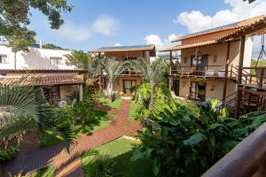 a courtyard of a house with trees and plants at Pousada Amandinha in Arraial d'Ajuda