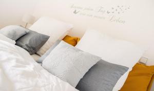 una cama con almohadas y un cartel que lee feliz despertar cada día en Ferienwohnung Glücksburg, en Twedterholz