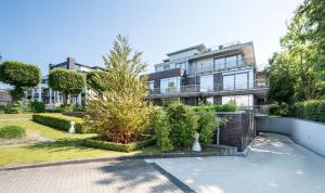 un edificio de apartamentos con arbustos y árboles delante de él en Ferienwohnung Glücksburg, en Twedterholz