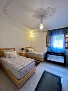 1 dormitorio con 2 camas y piano en Zina, en Marrakech