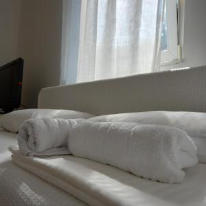 dos toallas blancas en una cama frente a una ventana en RIVIJERA LAKES, en Belgrado