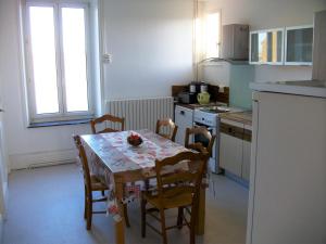 a kitchen with a table and chairs and a kitchen with a table and a table at Les rosieres 