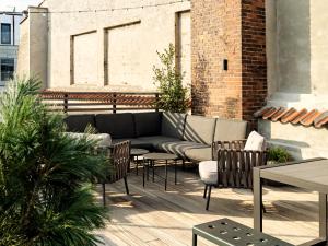 een patio met een bank, stoelen en tafels bij Apēron Apartment Hotel in Kopenhagen