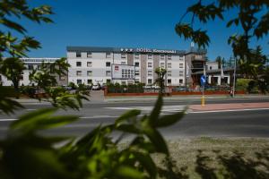 Biały budynek z hotelem na górze w obiekcie Hotel Kosmowski we Wrześni