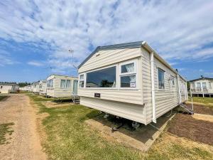 a white tiny house parked in a yard at Lovely 8 Berth Caravan At Manor Park Nearby Hunstanton Beach 23107s in Hunstanton