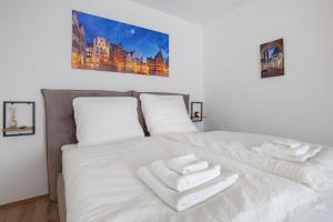 Una cama blanca con toallas blancas. en City Apartment in berühmter Lage, en Hildesheim