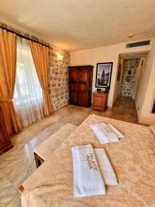 a bedroom with two white towels on a bed at Palace Jelena Rooms in Perast