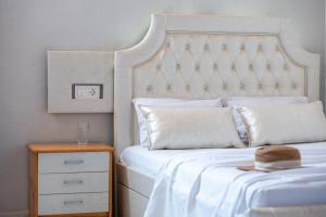 トロニにあるStudio Giannisのベッド(白いヘッドボード、木製のナイトスタンド付)