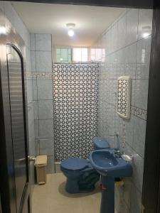 La salle de bains est pourvue de toilettes bleues et d'un lavabo. dans l'établissement Punta Blanca 5.5, Dpto Vista al mar, à Punta Blanca