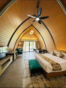 1 dormitorio con 1 cama grande y ventilador de techo en Dream Square Resort en Gazipur