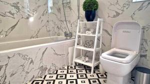 a bathroom with a white toilet and a bath tub at Stunning, clean, free parking home, ideal long stays in West Thurrock +50 photos