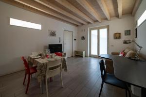 een woonkamer met een tafel en stoelen en een televisie bij #Franciacortalovers in Rodengo Saiano