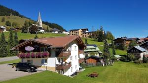 une maison avec une voiture garée devant dans l'établissement Walser Berge Appartements, à Mittelberg