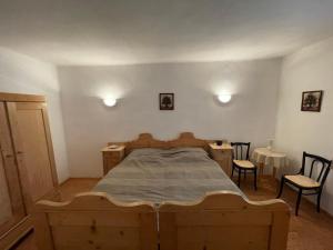 a bedroom with a wooden bed and two chairs at Körűnéző Vendégház in Nagykörů