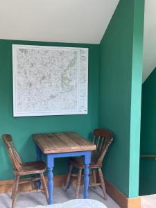 a table with two chairs and a map on the wall at 2 Guests Studio - Free Parking - Stunning Views in Bruton