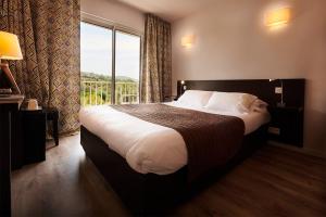 a bedroom with a large bed with a large window at Hotel & Appartements Acqua Dolce in Porticcio