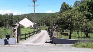an open gate to a driveway with a fence at Le moulin 