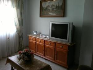 uma sala de estar com televisão numa cómoda de madeira em La Kentia em Rincón de la Victoria