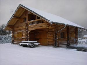 ein Blockhaus mit einem schneebedeckten Dach in der Unterkunft La fuste ardennaise in Haybes
