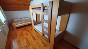two bunk beds in a room with wooden floors at Hradiste Cottage in Nová Bystřice