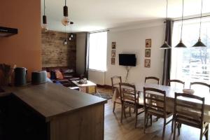 cocina y sala de estar con mesa y sillas en Gîte de l'Abeille, 