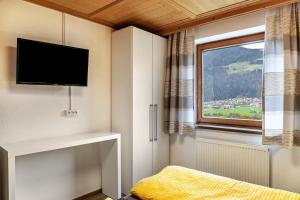 a bedroom with a tv and a window at Apart Spieljoch 90m2 in Bruck am Ziller