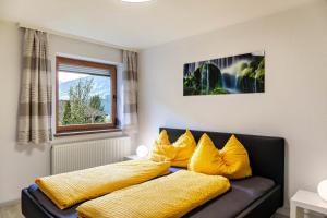 a couch with yellow pillows on it in a room at Apart Spieljoch 90m2 in Bruck am Ziller