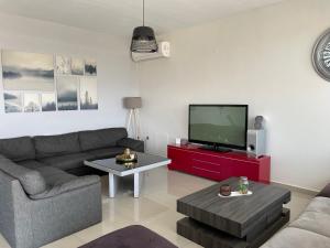 a living room with a couch and a tv at Discovery Villas in Limenaria