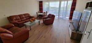 ein Wohnzimmer mit braunen Ledermöbeln und einem Tisch in der Unterkunft City Apartment Cologne-Weiden in Köln