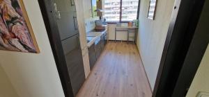 einen Flur, der zu einer Küche mit Holzboden führt in der Unterkunft City Apartment Cologne-Weiden in Köln