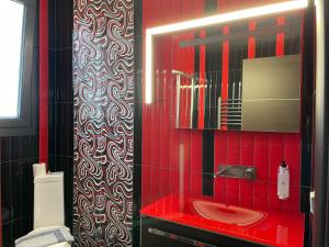 a red bathroom with a sink and a mirror at Discovery Villas in Limenaria +39 photos