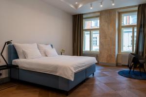Schlafzimmer mit einem Bett mit weißer Bettwäsche und Fenstern in der Unterkunft Luxury Old Town Apt, parking in Prag