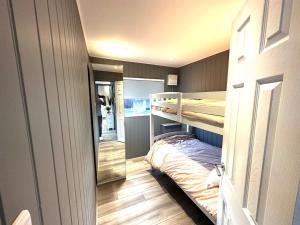 a room with two bunk beds and a mirror at Beautiful Chalet, 18 Cordova, Selsey Country Club in Selsey