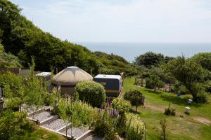 a yurt and a camper in a garden at Puckaster Cove Garden Yurt in Niton