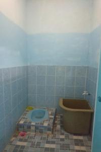 a blue tiled bathroom with a toilet and a tub at Penginapan Rindu Alam Soala Gogo in Tongging