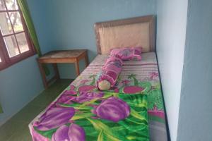 a small bed with a stuffed animal laying on it at Penginapan Rindu Alam Soala Gogo in Tongging