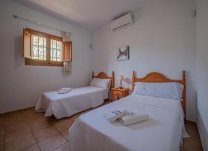 1 dormitorio con 2 camas y ventana en Casa Toril Cabo de Gata, en El Pozo de los Frailes