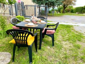 a black table and chairs sitting in the grass at La Rosa di Langa - Charming Panoramic House in Albaretto Della Torre 