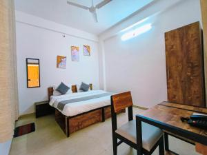 a bedroom with a bed and a table and a desk at White Town By Ashoka Group in Udaipur