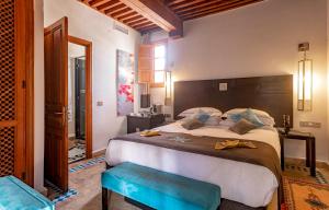 a bedroom with a large bed with a wooden headboard at Palais Amani in Fez