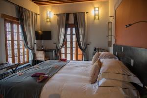 a bedroom with a large bed in a room with windows at Palais Amani in Fès